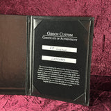 Gibson Custom Certificate of Authenticity on a textured red surface
