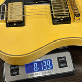 Yellow electric guitar on a digital scale displaying weight
