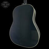 Back view of a guitar with a black finish on a black background, featuring the Tone Shop logo.