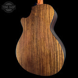 Close-up of a wooden guitar back with 'Tone Shop' logo in the corner.