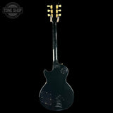 Back view of a black electric guitar with 'Tone Shop' logo.