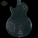 Back view of a transparent electric guitar with 'Tone Shop' branding.