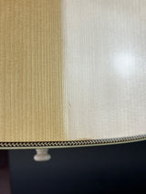 Close-up of a lampshade showing two fabric panels: one in a warm beige/cream ribbed texture and one in a lighter off-white textured fabric, separated by a decorative chevron-patterned band.