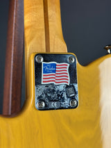 Close-up of a guitar with a brand label featuring an American flag design.
