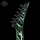 Guitar neck with green splatter design on a black background, featuring 'Tone Shop' logo.