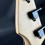 Close-up of a guitar's neck with tuners on a dark background