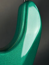 Close-up of a green guitar neck with a dark background