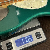 Green electric guitar on a digital scale displaying weight.