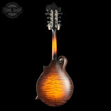 Wooden mandolin with a dark brown finish on a black background, featuring the Tone Shop logo.