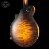 Close-up of a wooden mandolin on a black background with 'Tone Shop' logo.