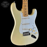 A cream-colored electric guitar with a white pickguard, maple neck, and gold-toned hardware, shown against a solid black background with a Tone Shop watermark in the top left corner.