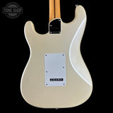 The back of a Fender Stratocaster electric guitar in cream, featuring a white pickguard and a maple neck, shown against a solid black background.