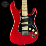Red electric guitar with a black pickguard on a white background