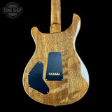 Back view of a wooden electric guitar with a blue pickguard on a black background, featuring 'Tone Shop' branding.