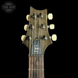 Guitar headstock with brand logo on a black background