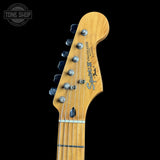 Close-up of a guitar headstock with brand logo on a black background