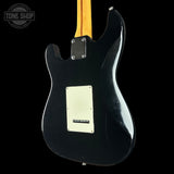 Black electric guitar body with a visible brand logo on a black background
