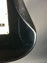 Close-up of a black object with visible wear and tear on a gray background