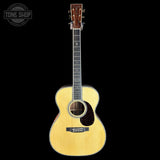 Acoustic guitar with a visible brand logo on a black background