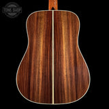 Wooden acoustic guitar back with a visible brand logo in the corner.