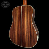 Close-up of a wooden acoustic guitar on a black background with 'Tone Shop' logo.