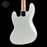 White electric bass guitar on a black background with 'Tone Shop' logo.