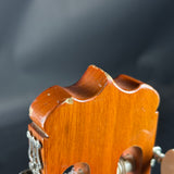 Close-up of a wooden violin f-hole against a dark background