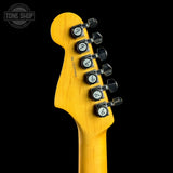 Close-up of the headstock of a Fender electric guitar, showing the maple wood neck and six black tuning pegs against a black background.