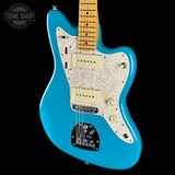 A turquoise blue electric guitar with a cream paisley patterned pickguard and maple neck, shown against a solid black background with a Tone Shop watermark in the top left corner.