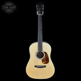 Acoustic guitar with a visible brand logo on a black background