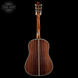 Acoustic guitar with a visible brand logo on a black background