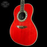 Red acoustic guitar with decorative rosette on a black background, featuring 'Tone Shop' logo.