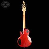 A red electric guitar shown from the back, featuring a glossy cherry red finish, a natural wood neck, and black hardware, photographed against a solid black background with a Tone Shop watermark in the top left corner.