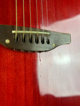 Close-up of a guitar's soundhole and strings on a red background