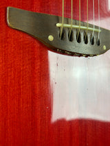 Close-up of a guitar's soundhole with a red background