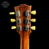 Close-up of a guitar headstock with tuning pegs on a black background, featuring 'Tone Shop' branding.