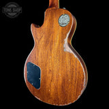 Back view of a wooden electric guitar with a visible brand logo on a black background.