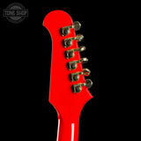 Close-up of a red electric guitar's headstock with tuning pegs on a black background, featuring 'Tone Shop' logo.