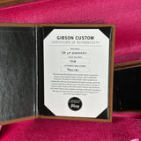 Gibson Custom Certificate of Authenticity inside a guitar case with a pink interior.