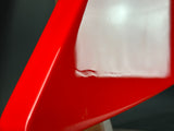 Close-up of a red plastic object with a white square inside