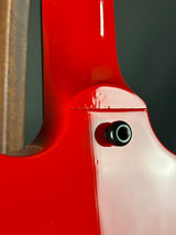 Close-up of a red bicycle frame with a black bolt on a dark background