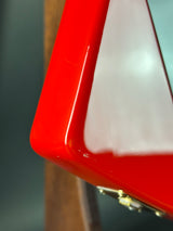 Close-up of a red object with a reflective surface on a blurred background