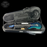 Blue electric guitar in an open hard-shell case with 'Tone Shop' branding.