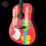 Woodstock-themed guitar with colorful design on a black background