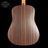 Back view of a wooden acoustic guitar with 'Tone Shop' logo.