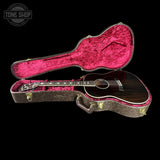 Acoustic guitar in a pink-lined case with 'Tone Shop' logo.