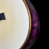 Close-up of a guitar with a purple and white design on a black background