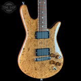Electric guitar with a wood finish on a black background, featuring the Tone Shop logo.