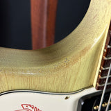 Close-up of a guitar's neck and headstock with a brand logo.
