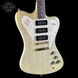 Electric guitar with a blonde finish and white pickguard on a black background, featuring the Tone Shop logo.